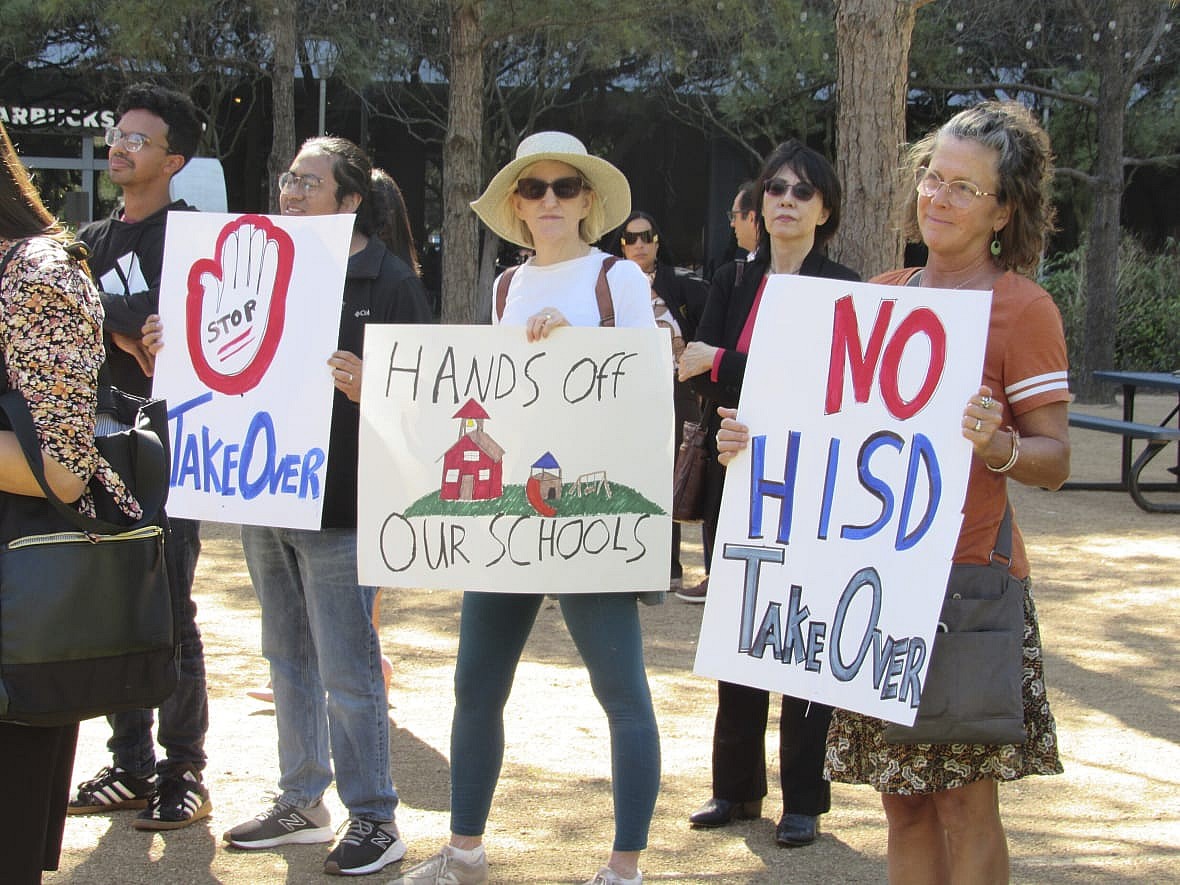 Protesters hold up signs