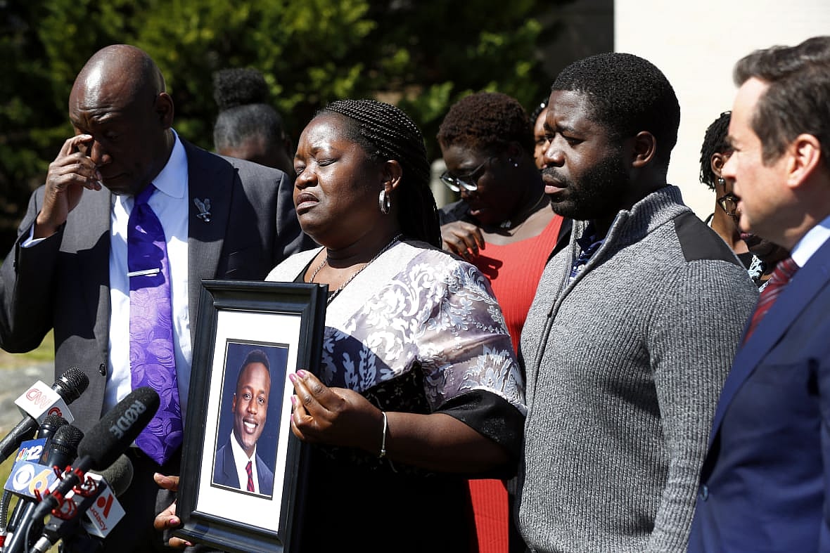 Attorney Ben Crump, Caroline Ouko with a picture of her son Irvo Otieno, son Leon Ochieng and attorney Mark Krudys