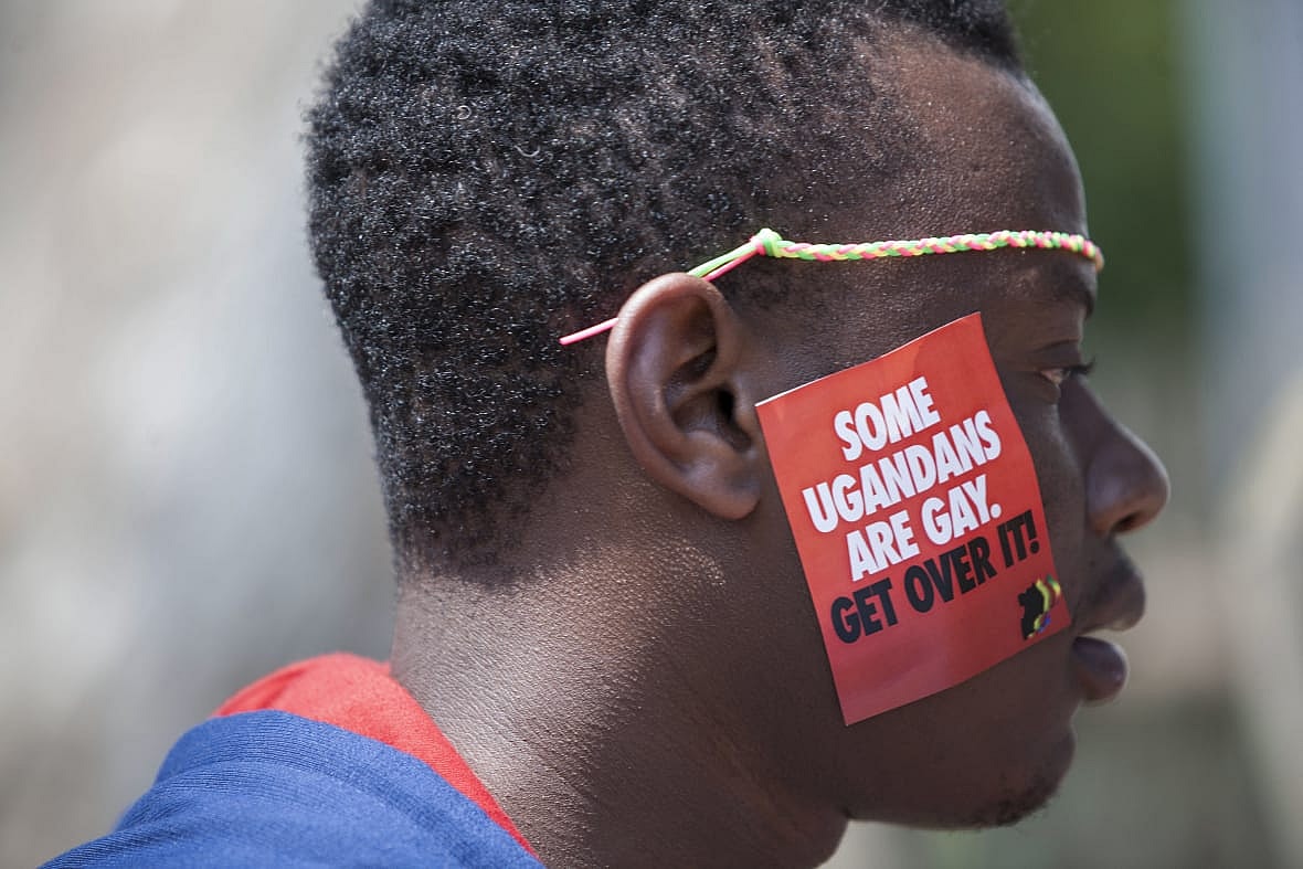 A Ugandan man wears a sticker reading "Some Ugandans are gay. Get over it!"