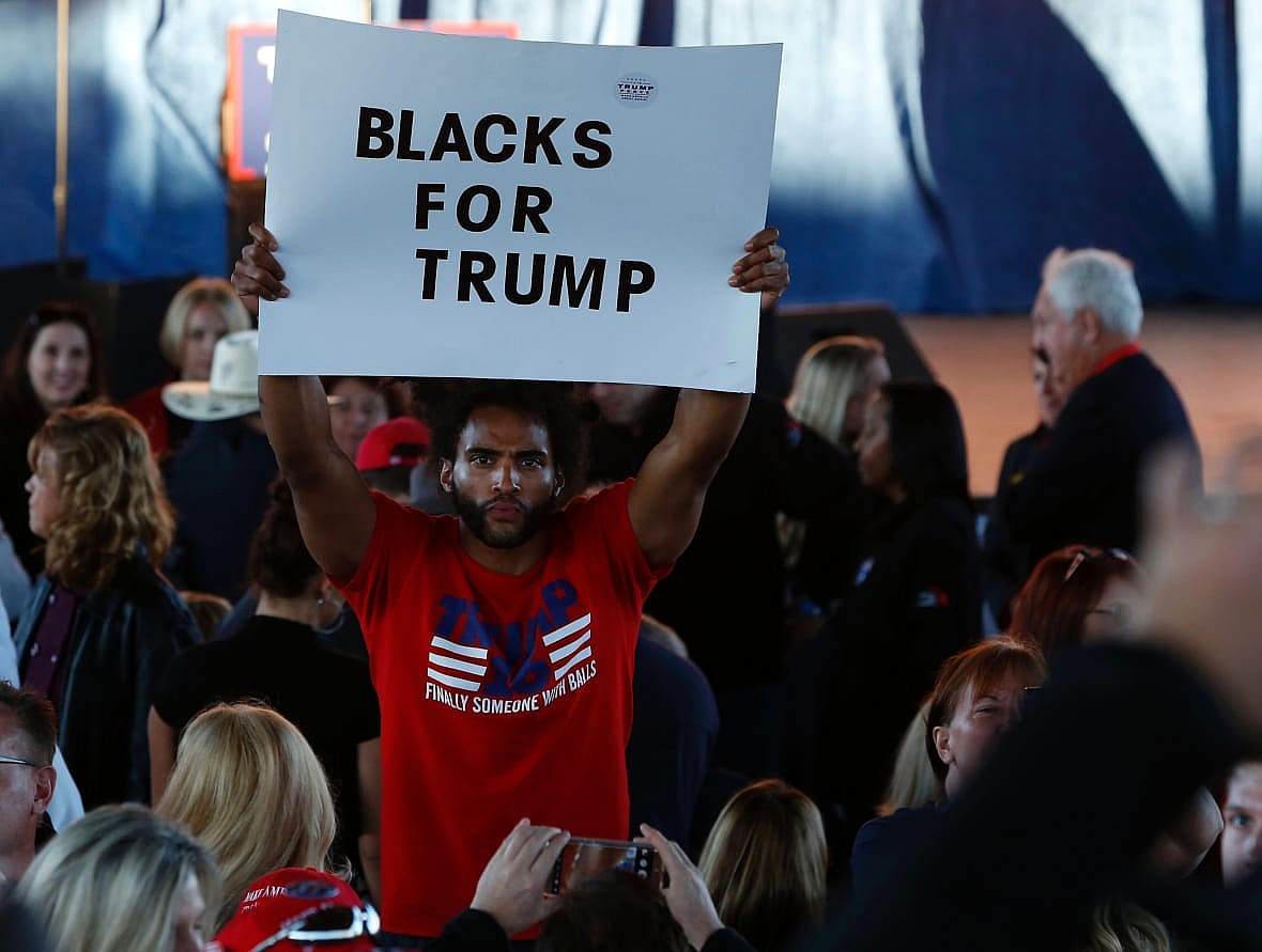 A man hold a “Blacks for Trump” sign