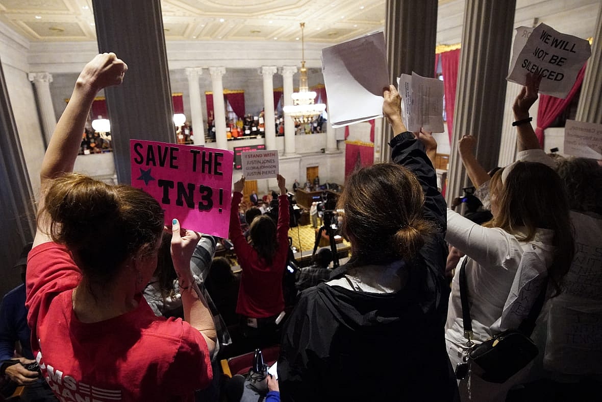 Gun reform and “Tennessee Three” supporters raise signs in the gallery of the House chamber
