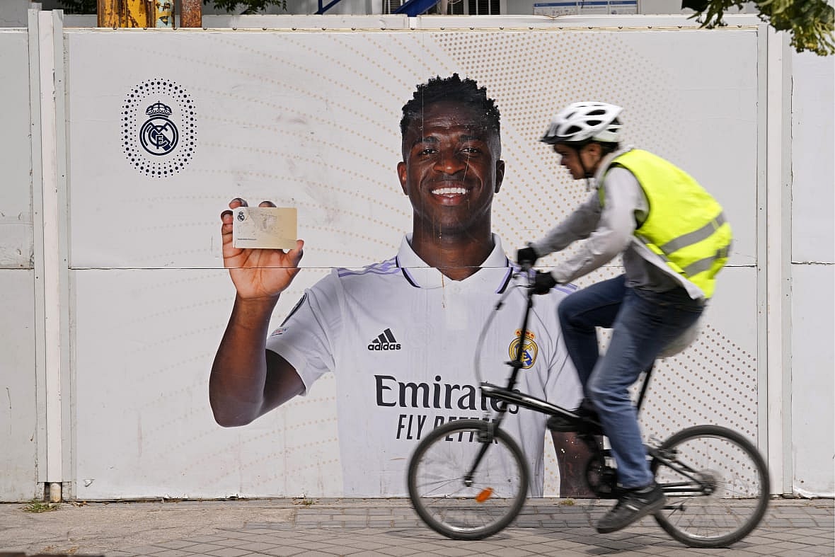 A cyclist rides past a poster of Real Madrid’s Vinicius Junior