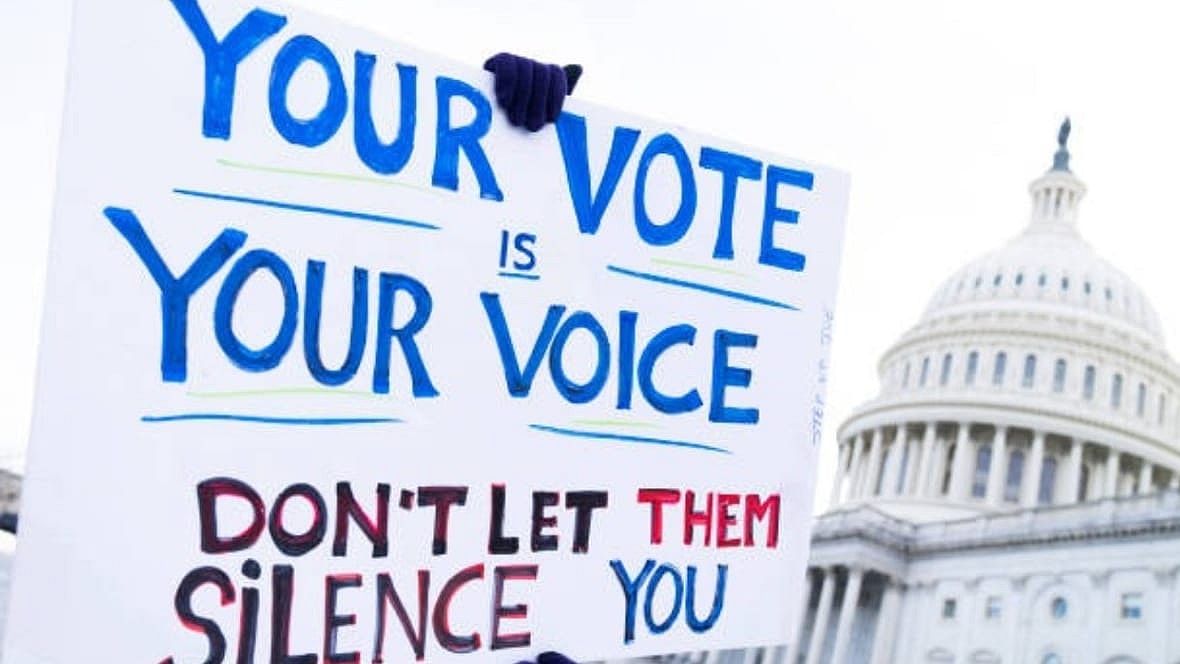 A demonstrator holds a sign supporting voting rights