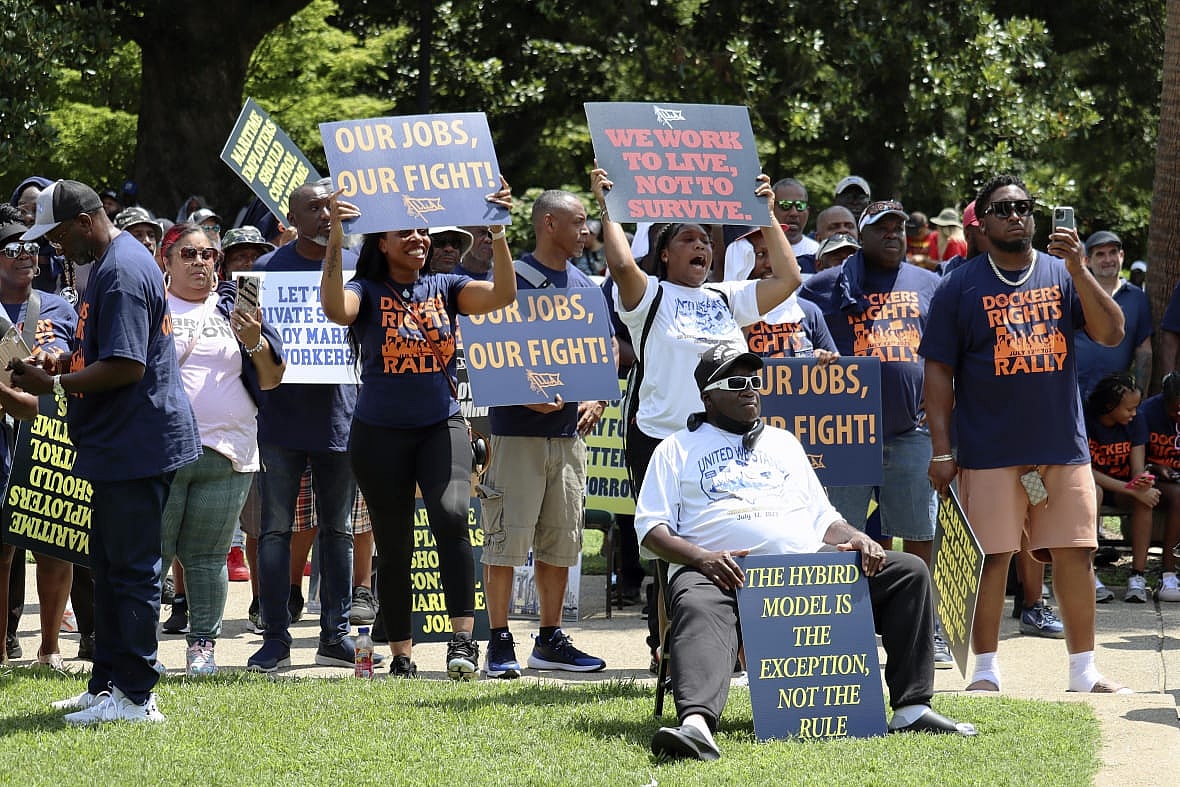Workers hold signs supporting labor organizers