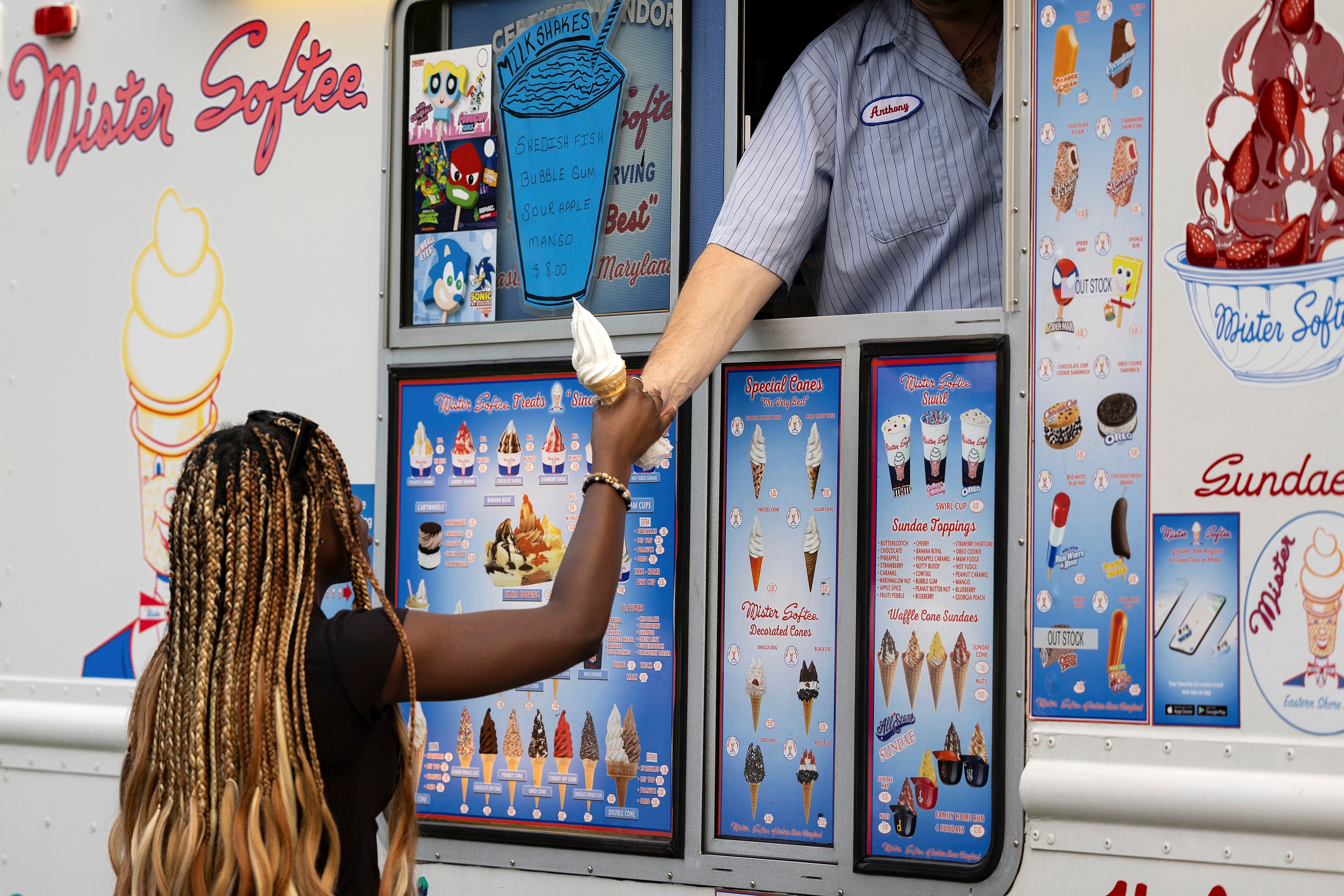 A woman buys an ice cream cone from a Mister Softee truck