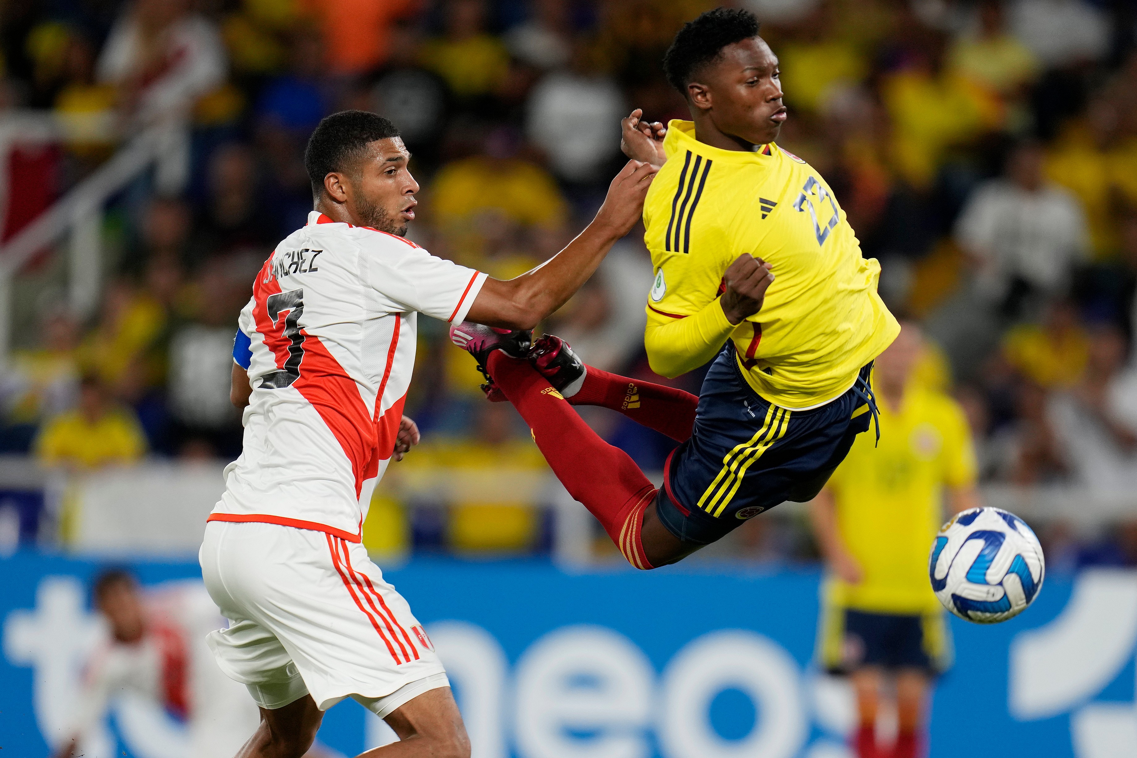 Peru’s Jose Sanchez and Colombia’s Jorge Cabezas battle for the ball
