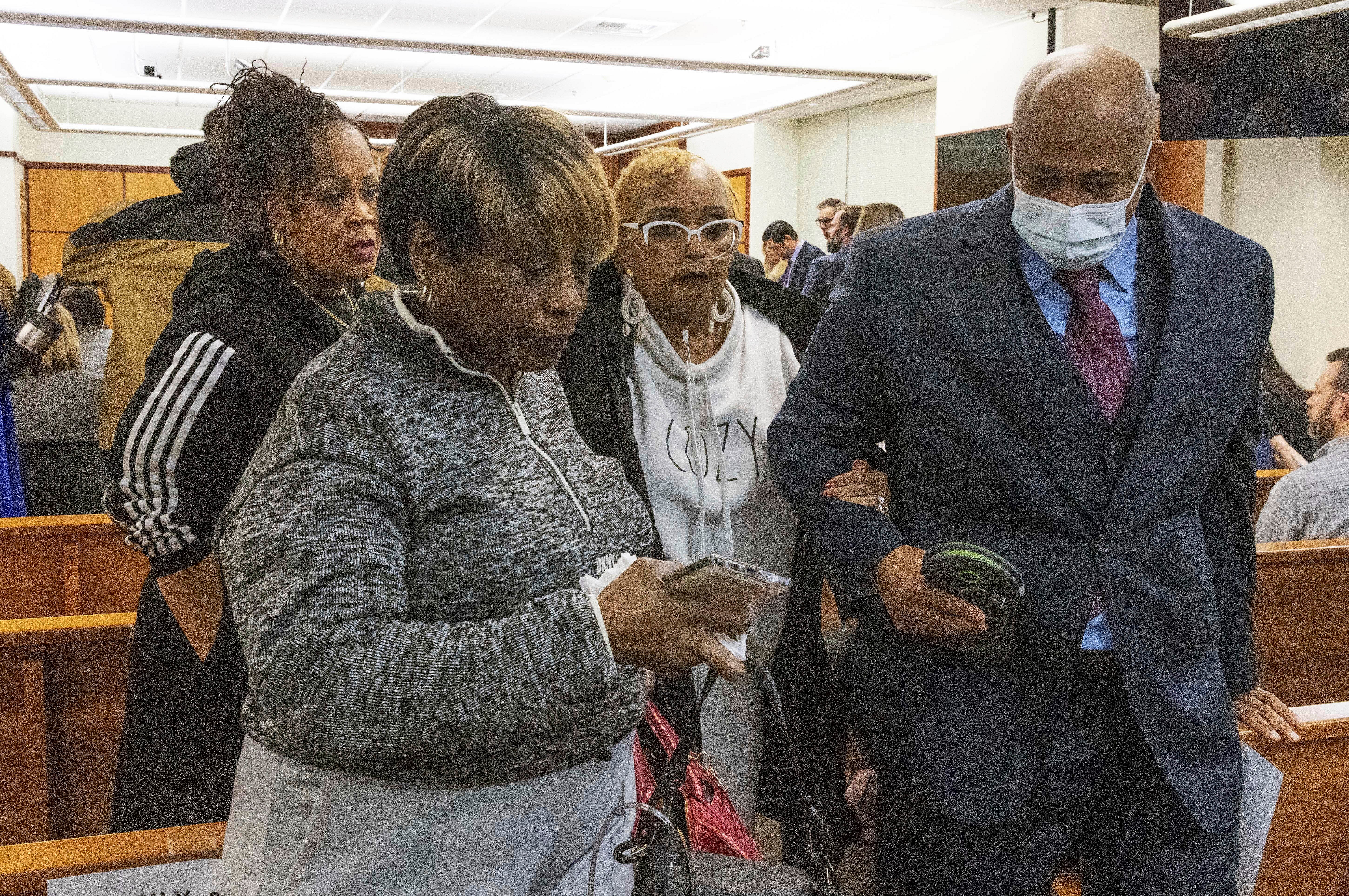 Manuel Ellis’s mother, Marcia Carter-Patterson, second from right, and family attorney James Bible