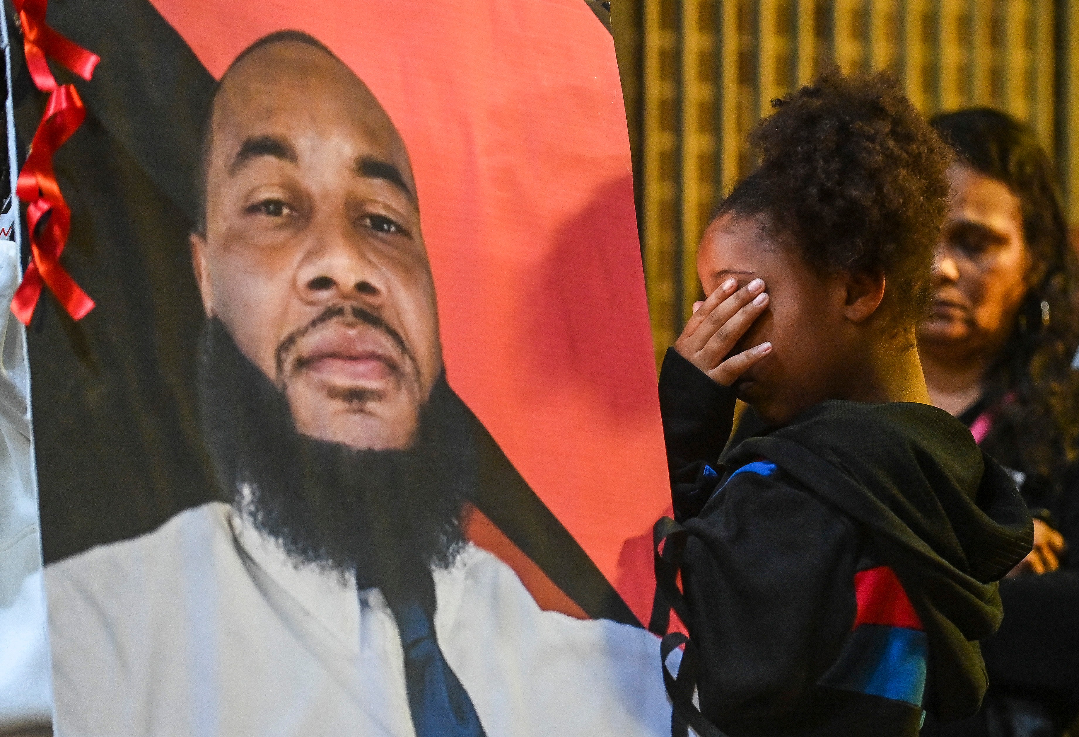 A girl prays for Stephen Perkins during a vigil