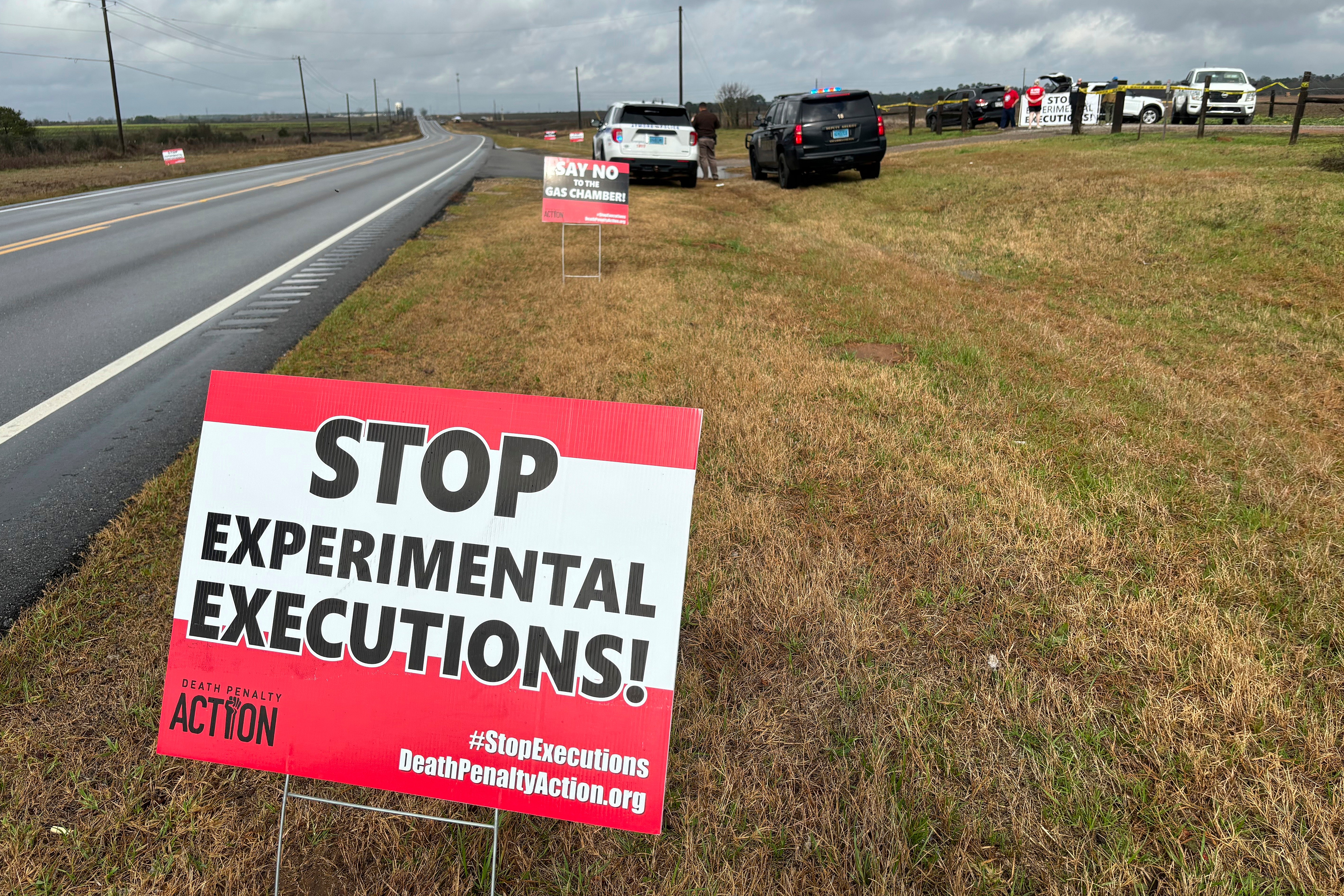 Anti-death penalty activists place signs along the road