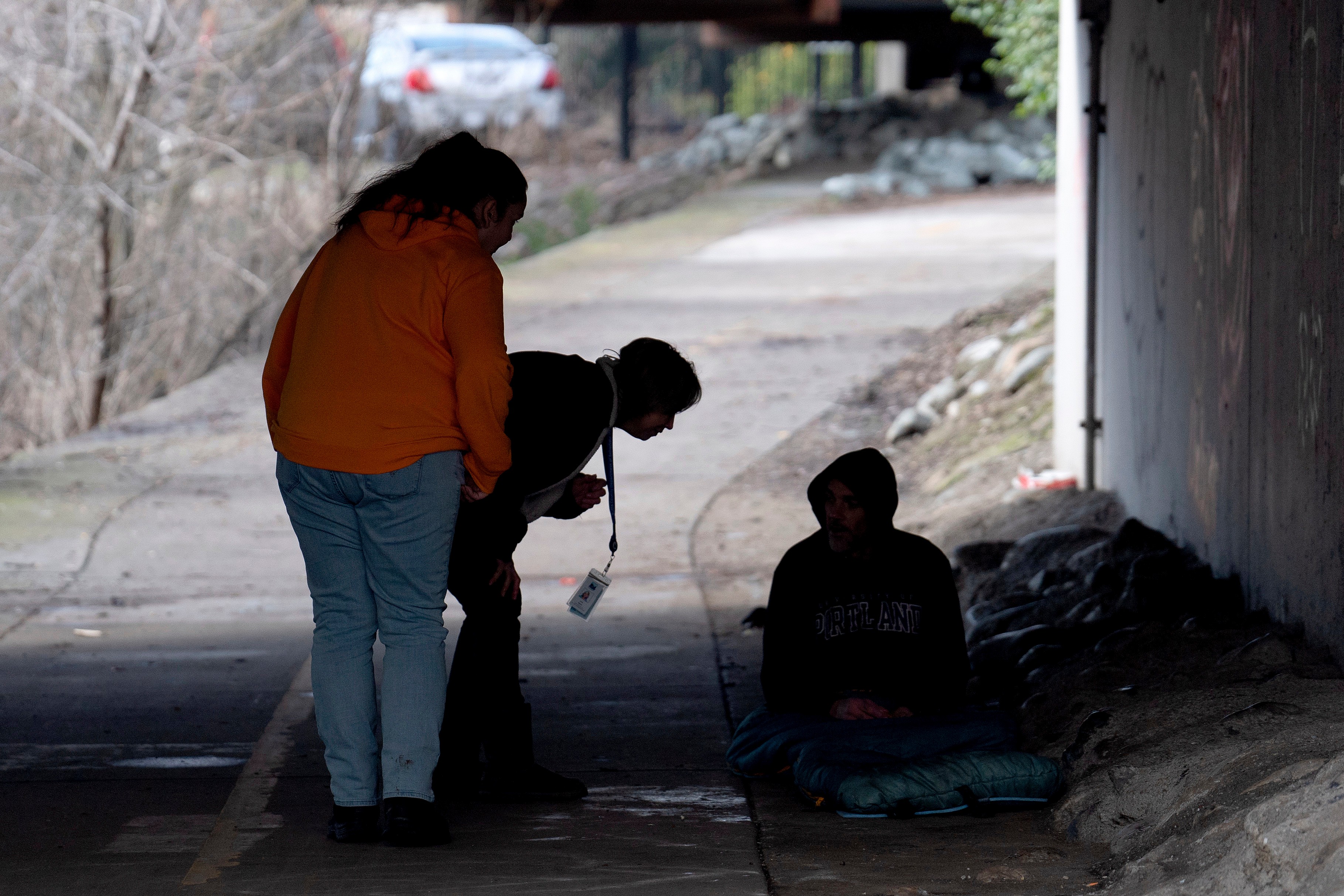 Members of the Resiliency Empowerment Support Team Letha Croff and Torie Baxter talk to a homeless person 