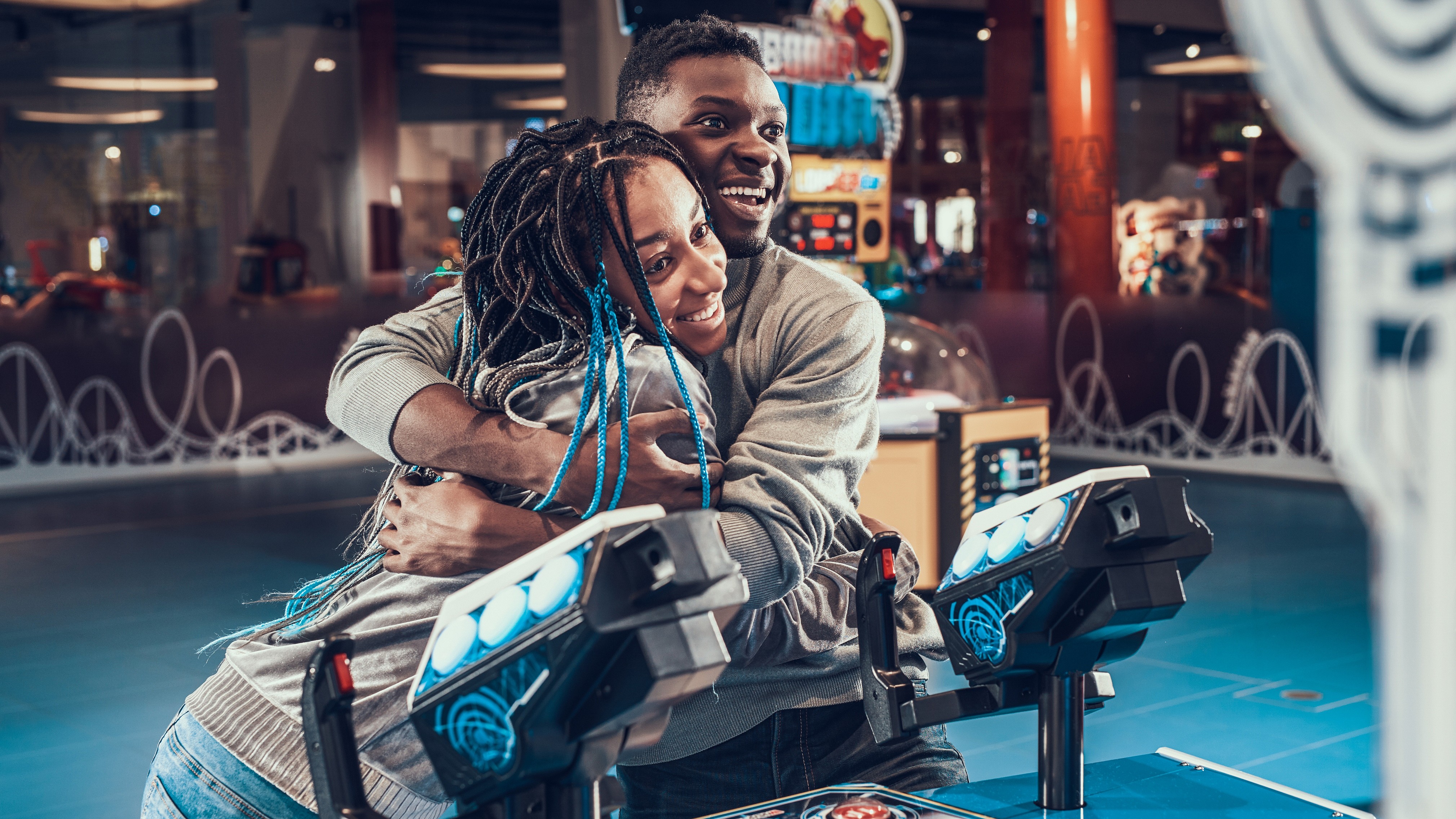 A couple embraces by a video game