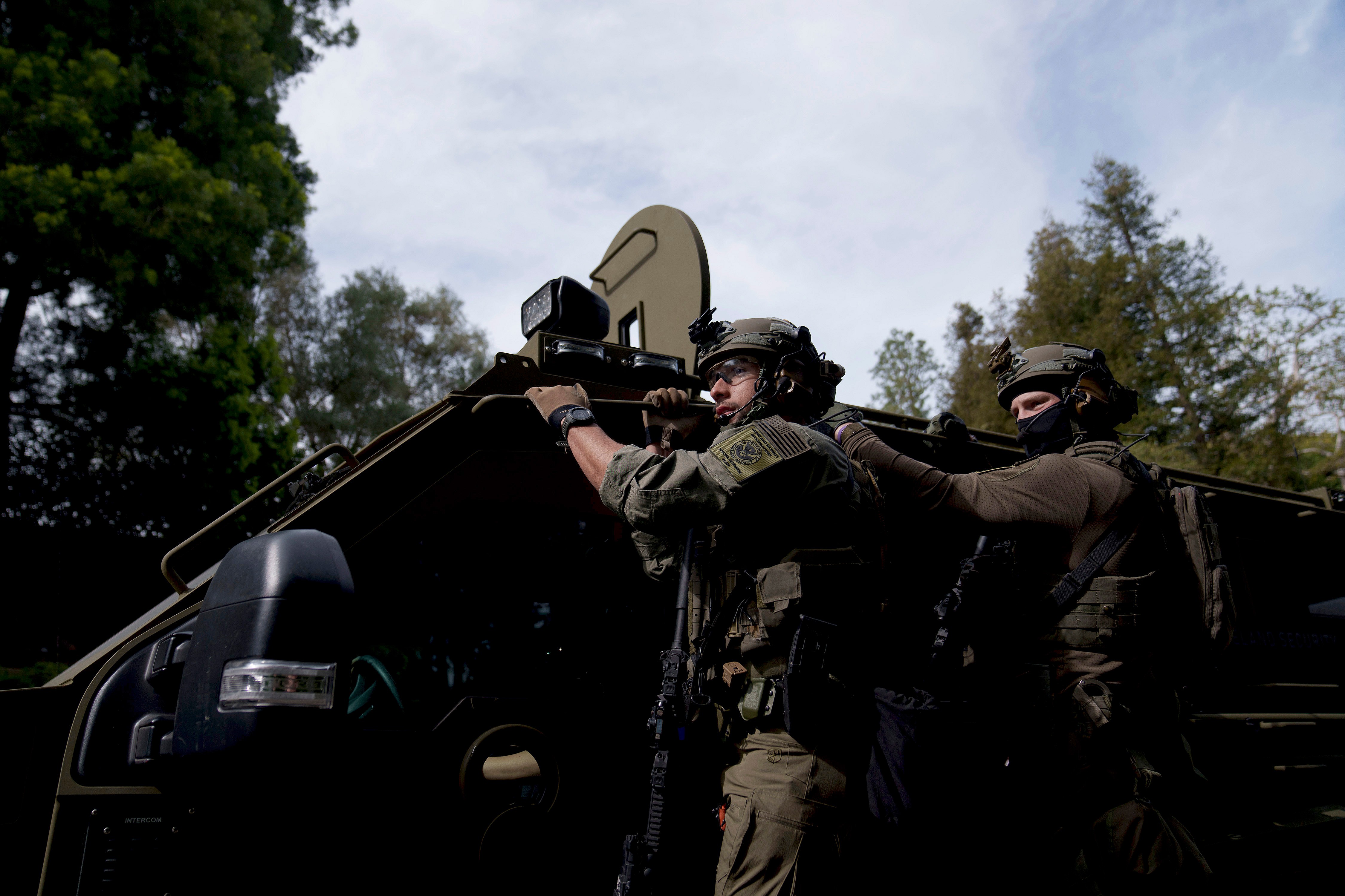 Law enforcement officers ride on a vehicle on a street near a property in Los Angeles belonging to Sean “Diddy” Combs