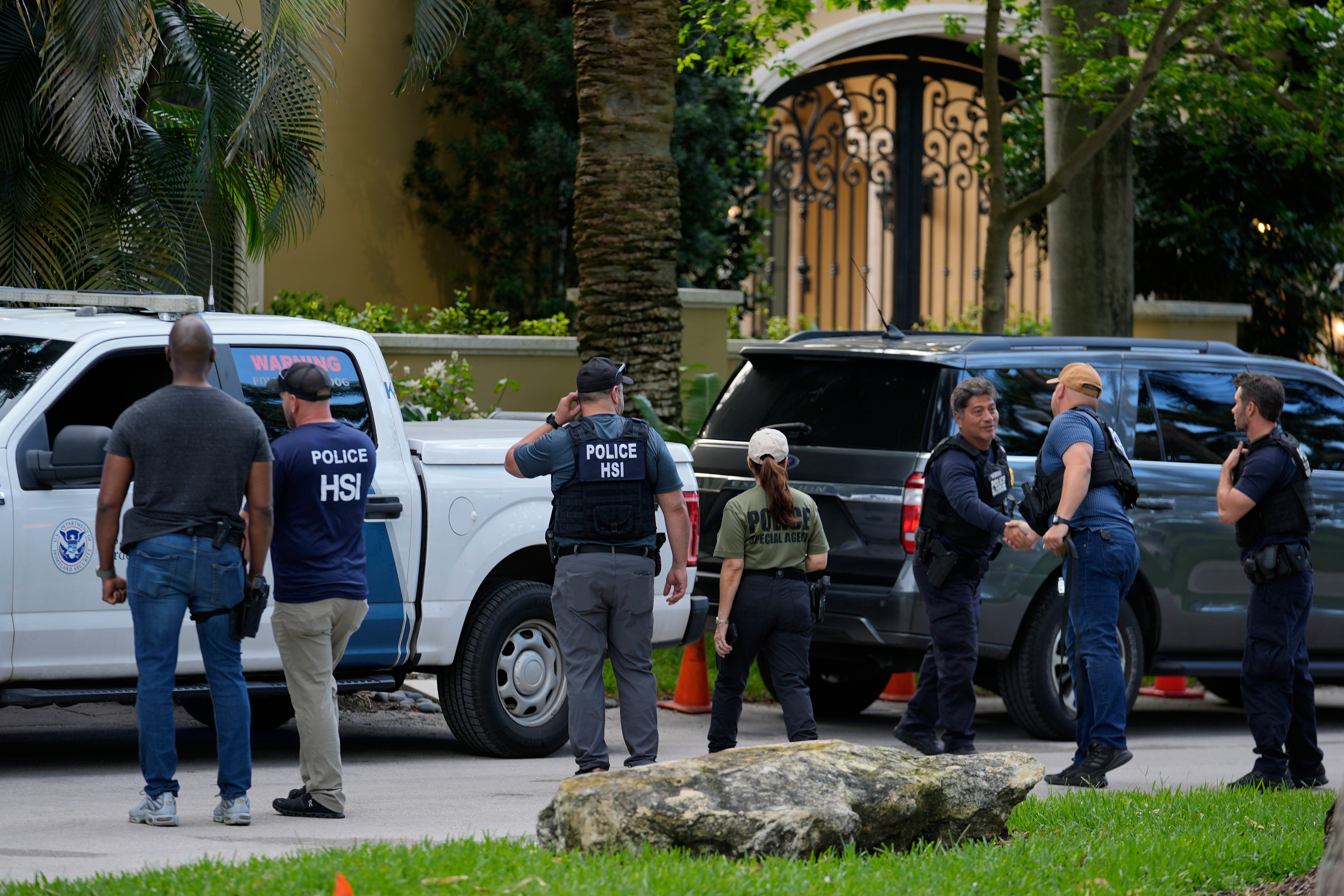 Law enforcement agents stand at the entrance to a property belonging to rapper Sean “Diddy” Combs