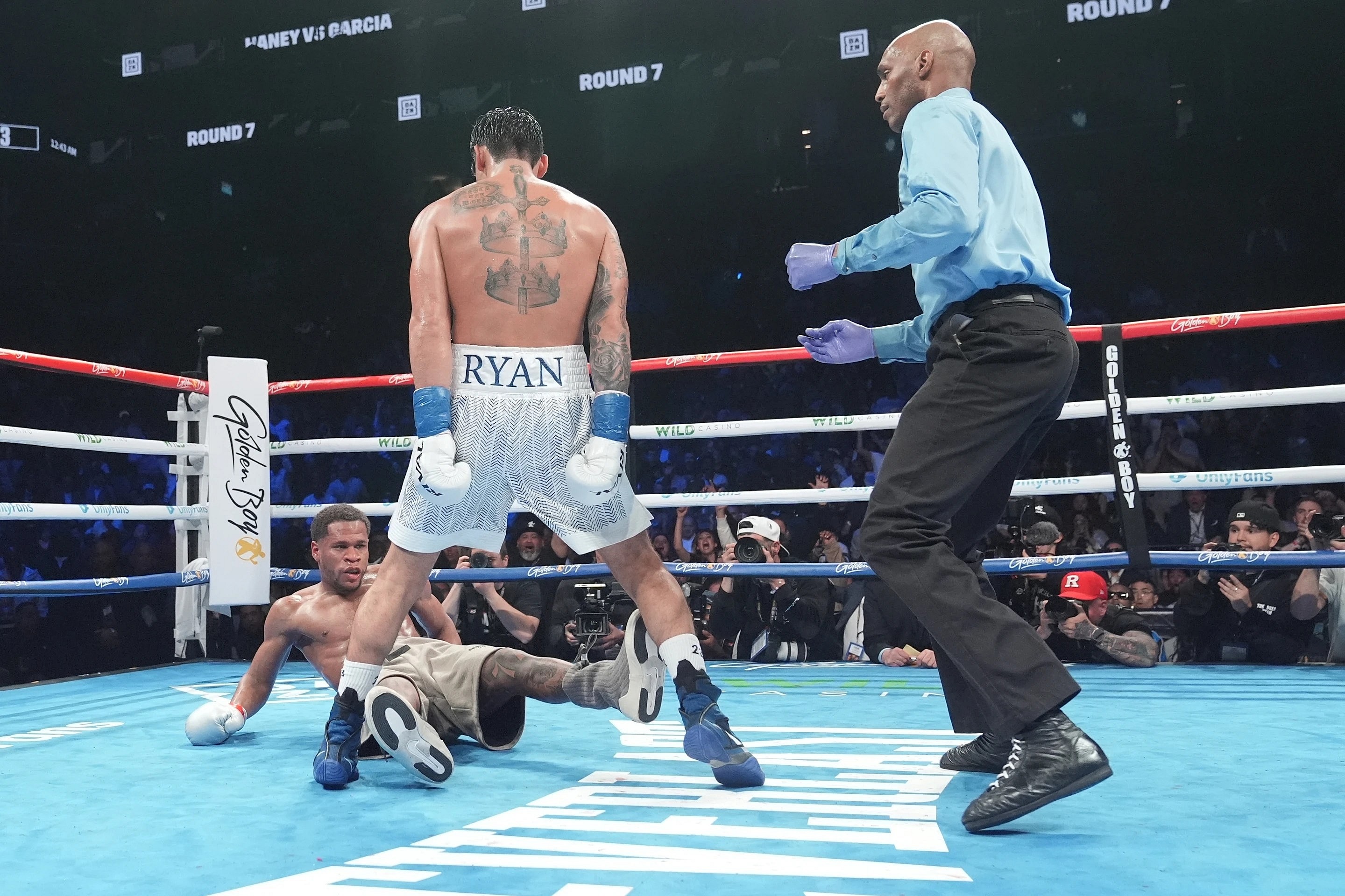 Boxer Ryan Garcia stands over Devin Haney after knocking him down