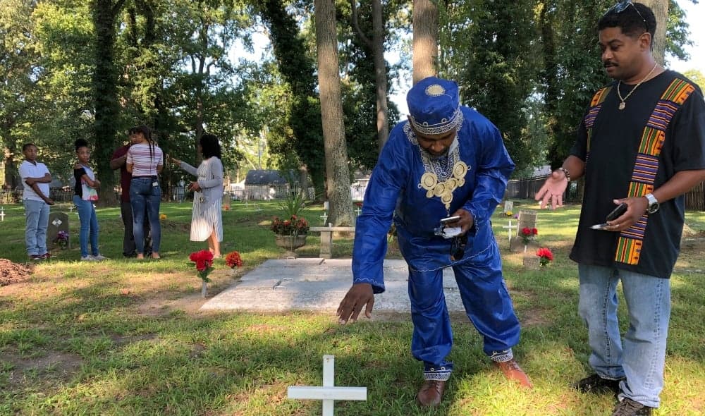 Andre Bradshaw, left, and Eric Jackson stand at an unmarked grave at the Tucker Family Cemetery in Hampton, Va. on Friday, Aug. 23, 2019. They are part of a larger family that traces its roots back to the first enslaved Africans to arrive in what is now Virginia in 1619. (AP Photo/Ben Finley) thegrio.com