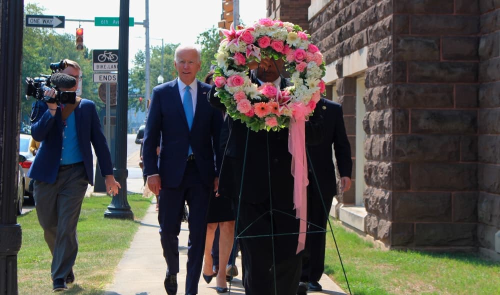 Former Vice President and presidential candidate Joe Biden, center left, joins Sen. Doug Jones and Birmingham Mayor Randall Woodfin at a wreath laying after a service at 16th Street Baptist Church in Birmingham, Ala., Sunday, Sept. 15, 2019. Visiting the black church bombed by the Ku Klux Klan in the civil rights era, Democratic presidential candidate Biden said Sunday the country hasn't "relegated racism and white supremacy to the pages of history" as he framed current tensions in the context of the movement's historic struggle for equality. (Ivana Hrynkiw/The Birmingham News via AP) thegrio.com