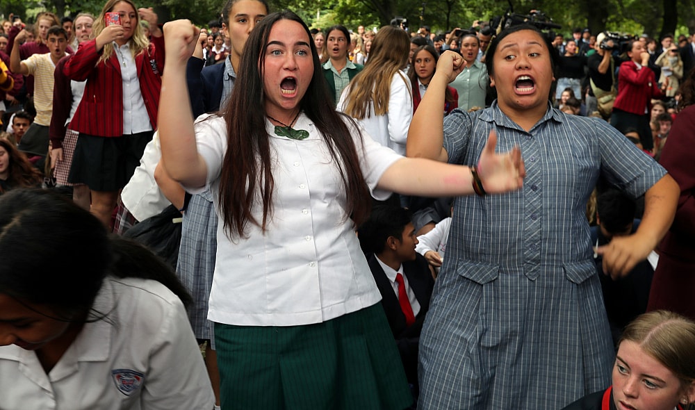 Students perform the Haka during a vigil to commemorate victims of Friday's shooting, outside the Al Noor mosque in Christchurch, New Zealand, Monday, March 18, 2019. Three days after Friday's attack, New Zealand's deadliest shooting in modern history, relatives were anxiously waiting for word on when they can bury their loved ones. (AP Photo/Vincent Thian) thegrio.com