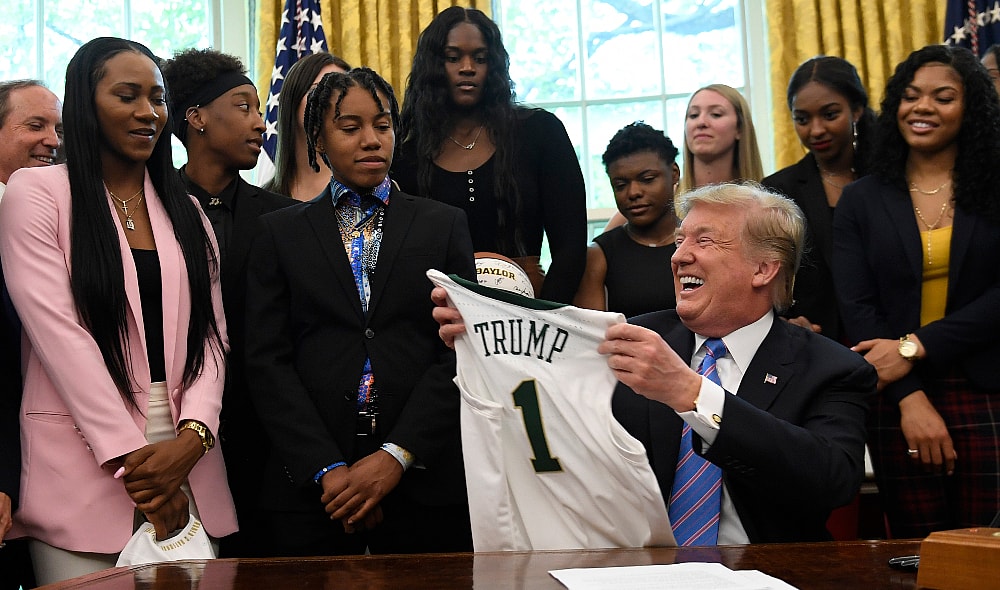 President Donald Trump holds up a jersey that was presented to him as he welcomed members of the Baylor women's basketball team, who are the 2019 NCAA Division I Women's Basketball National Champions, to the Oval Office of the White House in Washington, Monday, April 29, 2019. (AP Photo/Susan Walsh) thegrio.com