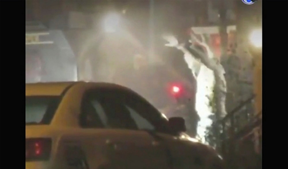 In this image from video taken by Bill Trenwith on Wednesday, Aug. 14, 2019, a man exits a building with hands up in Philadelphia, Pennsylvania. A gunman who opened fire on police Wednesday as they were serving a drug warrant in Philadelphia, wounding six officers and triggering a standoff that extended into the night, is in police custody, authorities said. (Bill Trenwith via AP) thegrio.com