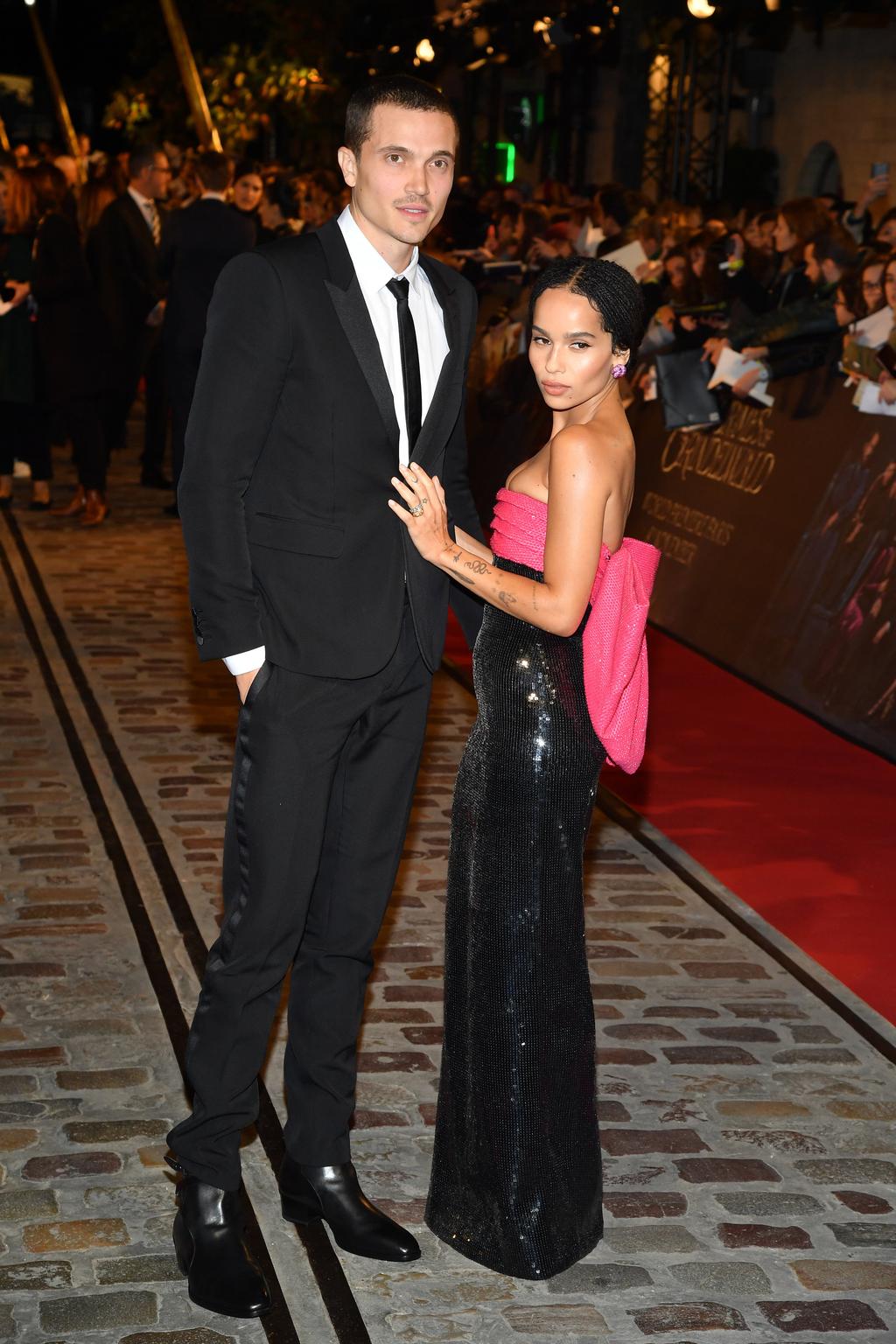 Actors Karl Glusman, in a black suit, and Zoe Kravitz, in a black sequined dress with pink top