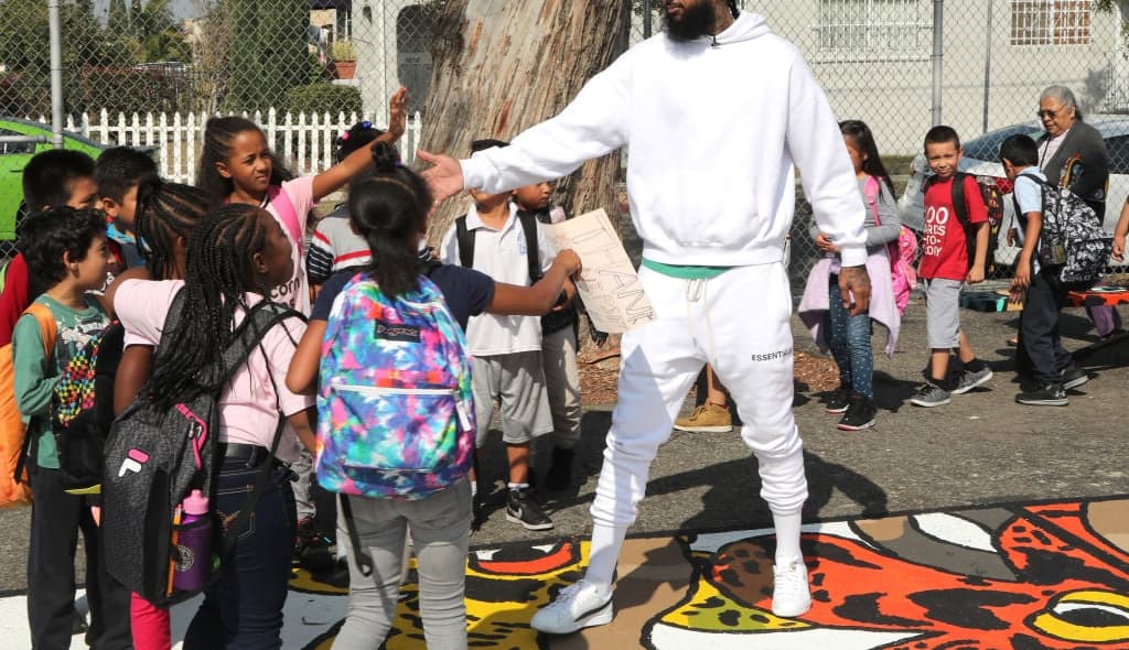 LOS ANGELES, CA - OCTOBER 22: Nipsey Hussle greets kids at the Nipsey Hussle x PUMA Hoops Basketball Court Refurbishment Reveal Event on October 22, 2018 in Los Angeles, California. (Photo by Jerritt Clark/Getty Images for PUMA) thegrio.com