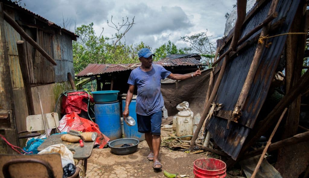 A man checks damages in a house near the highway