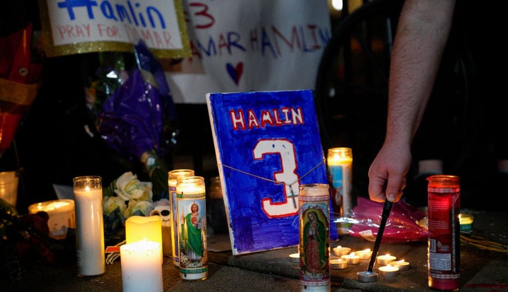 A memorial for Buffalo Bills safety Damar Hamlin showing candles and a plaque