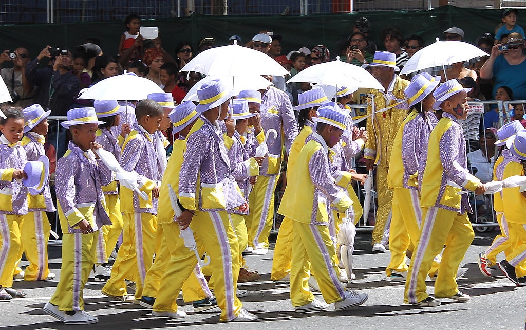 A parade of children dressed in yellow and lavender