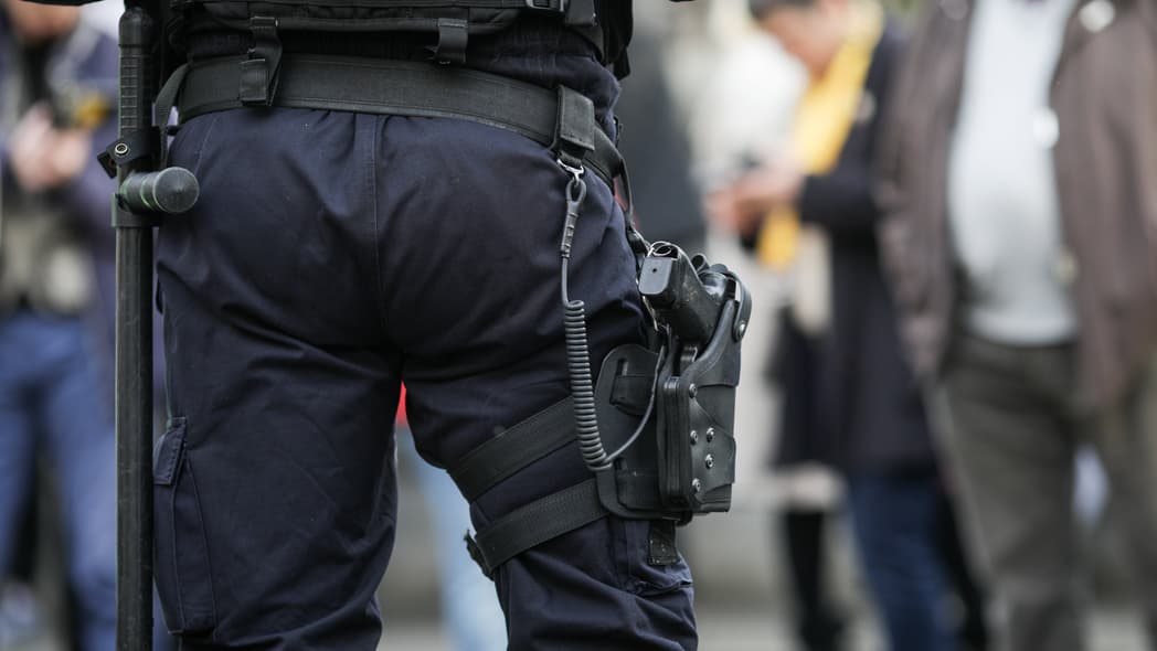 Details of the security kit of a riot police officer (including handcuffs, 9mm handgun, radio station and baton)