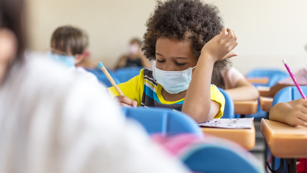 Black chool boy wearing mask and study in classroom