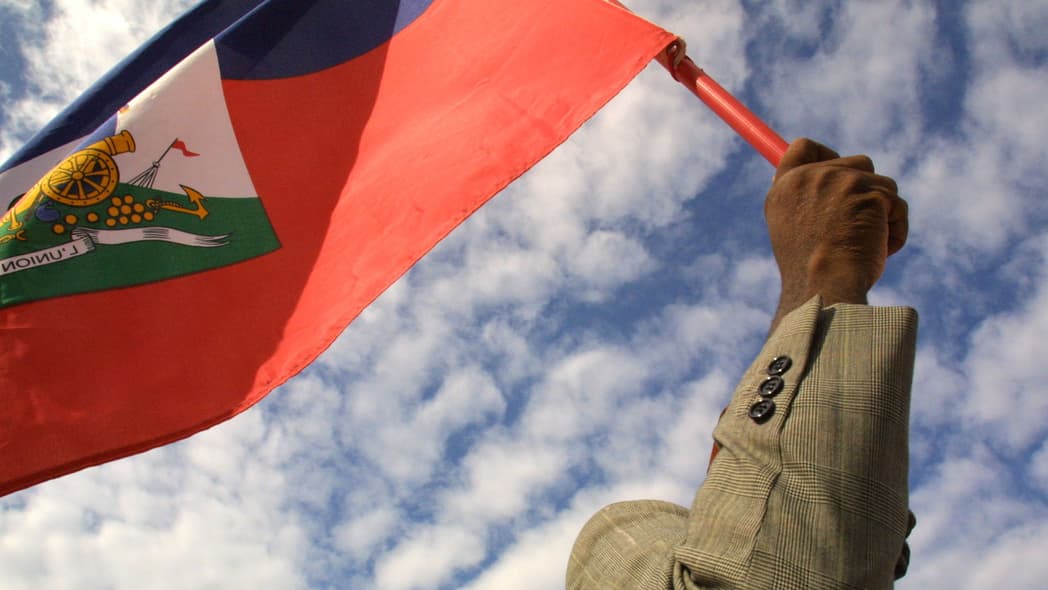 A man holds a Haitian flag