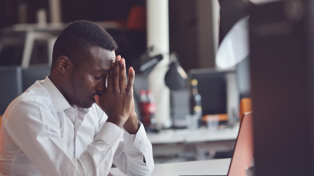 Black man stressed at office, theGrio.com