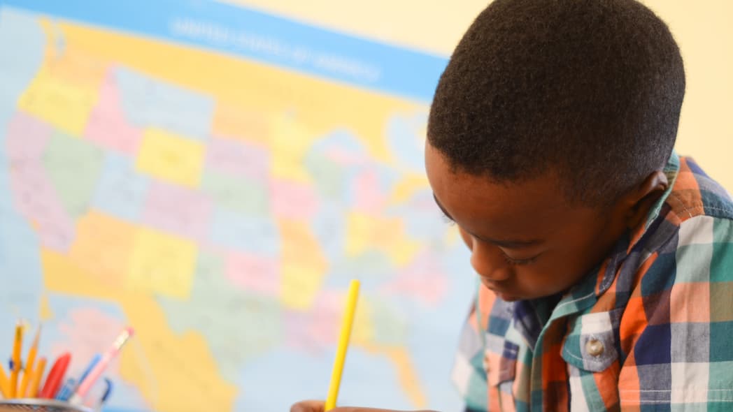 Black student doing school work in classroom, theGrio.com