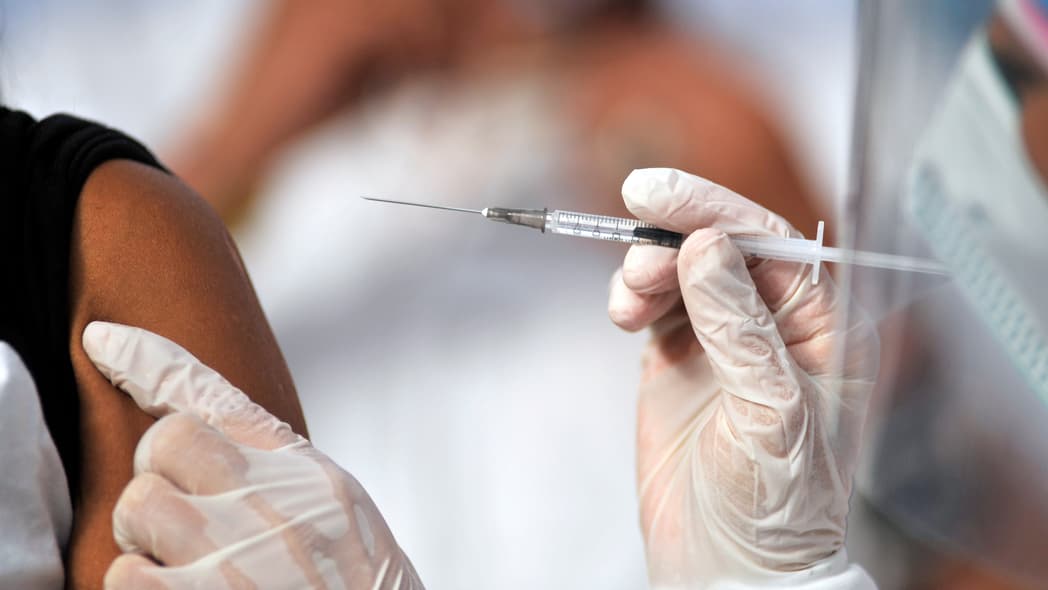 A health worker gives a man a shot of the Jenssen COVID-19 vaccine from the Johnson & Johnson - theGrio.com