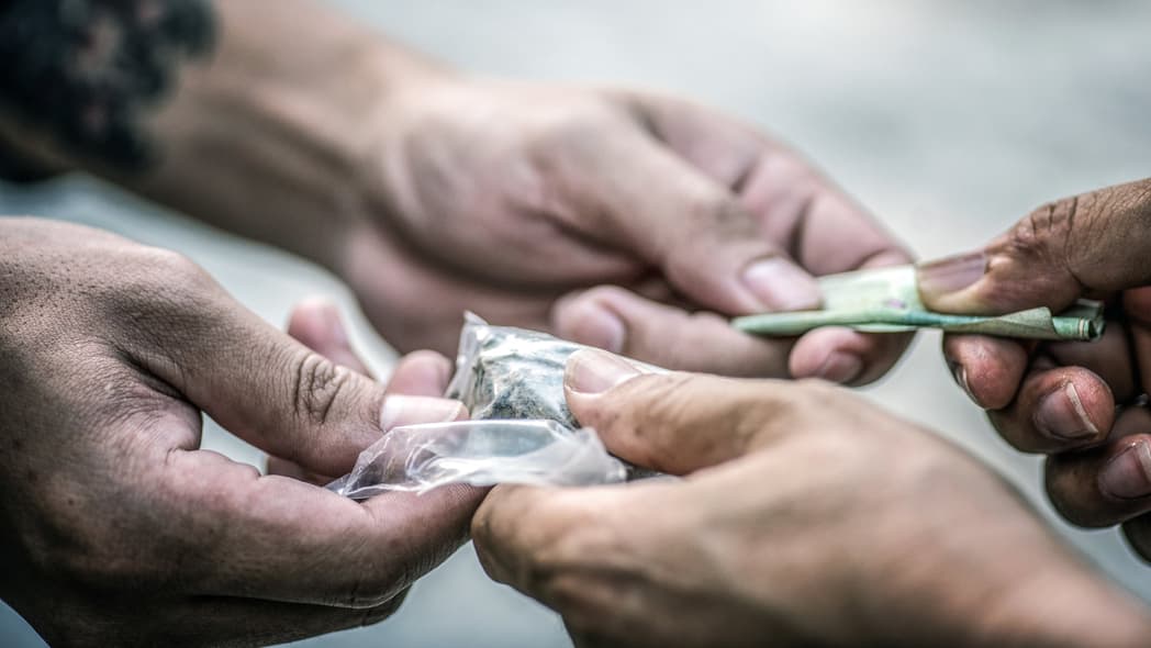 Hands of people completing a drug transaction