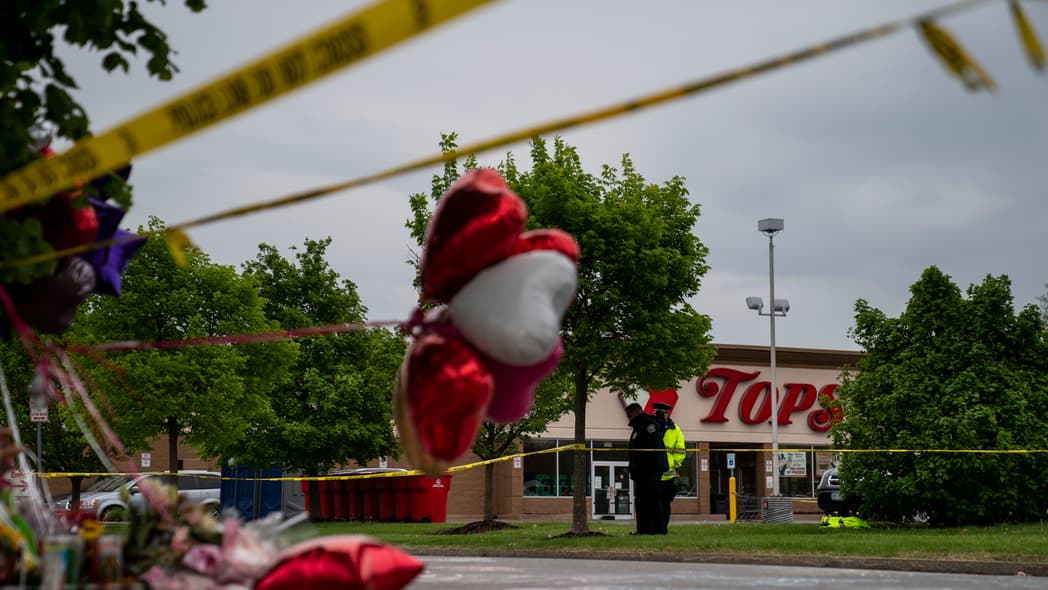 People gather at the scene of a mass shooting at Tops Friendly Market