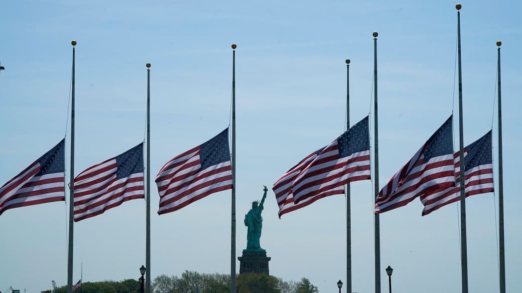 U.S. flags, across New York Bay from the Statue of Liberty, fly at half-staff