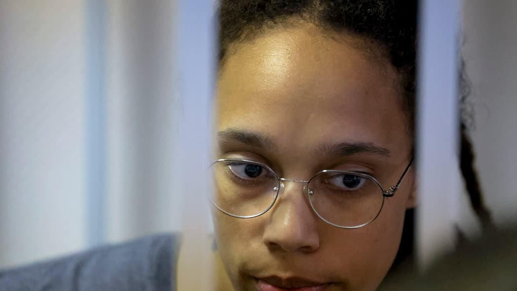 WNBA star and two-time Olympic gold medalist Brittney Griner stands in a cage in a courtroom in Russia