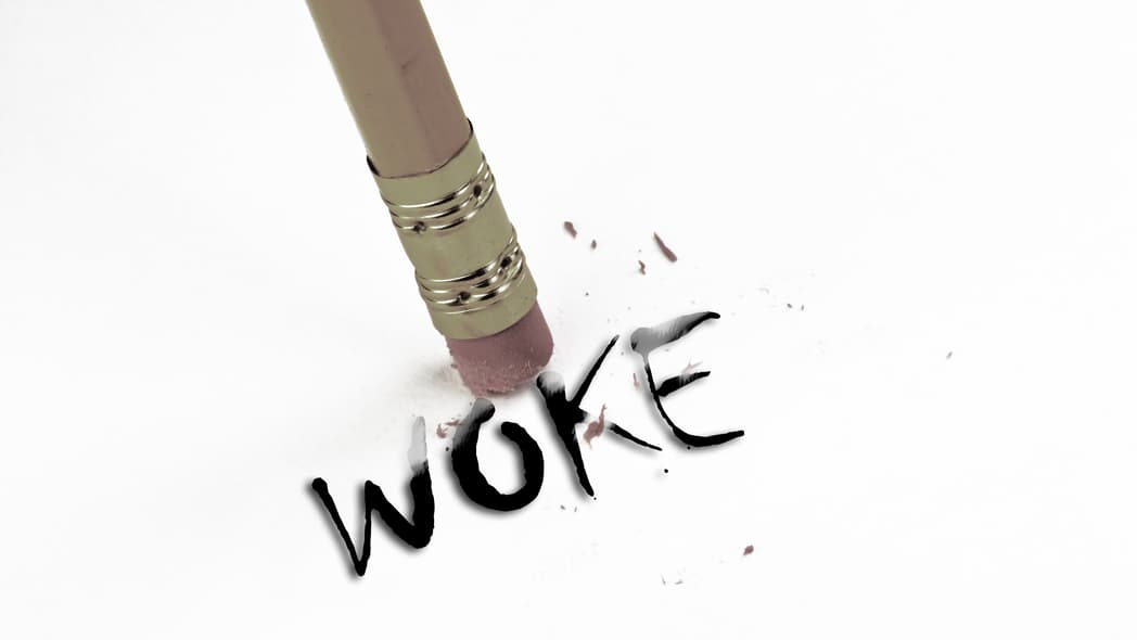 The eraser end of a pencil by the word "Woke"