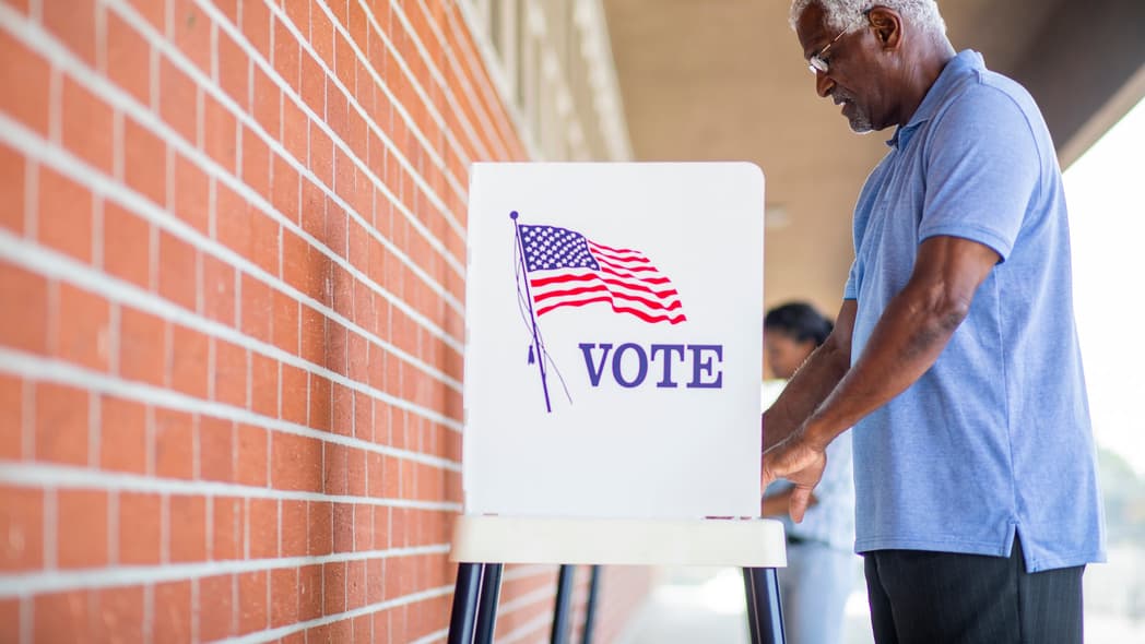 A man stands at a voting booth