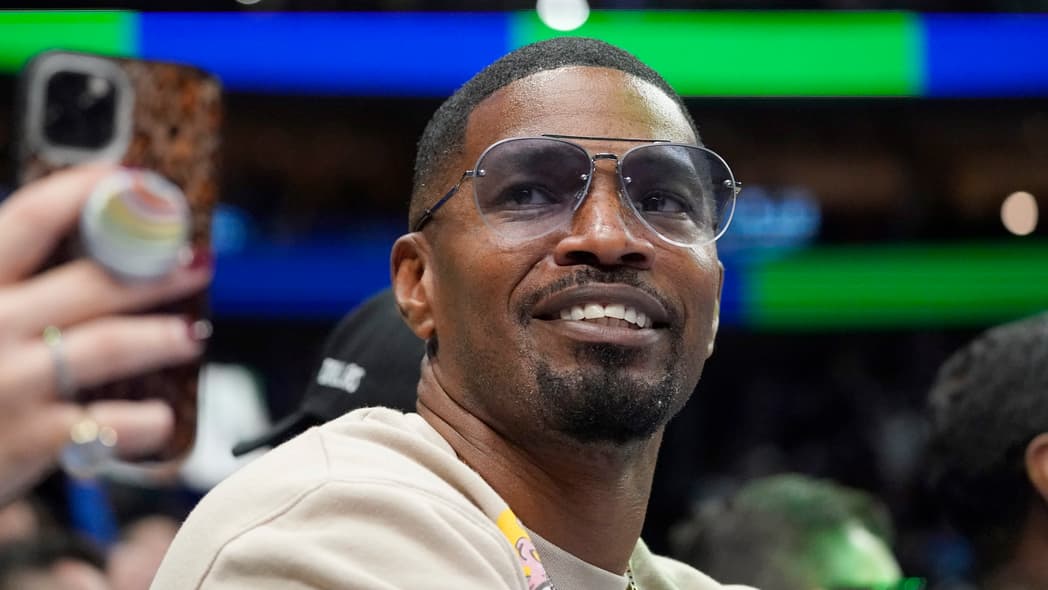 Actor Jamie Foxx wearing a white top and sunglasses