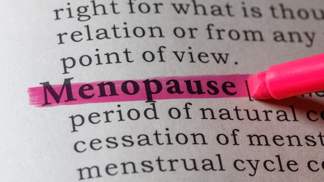 A dictionary page with the word "menopause" highlighted in pink