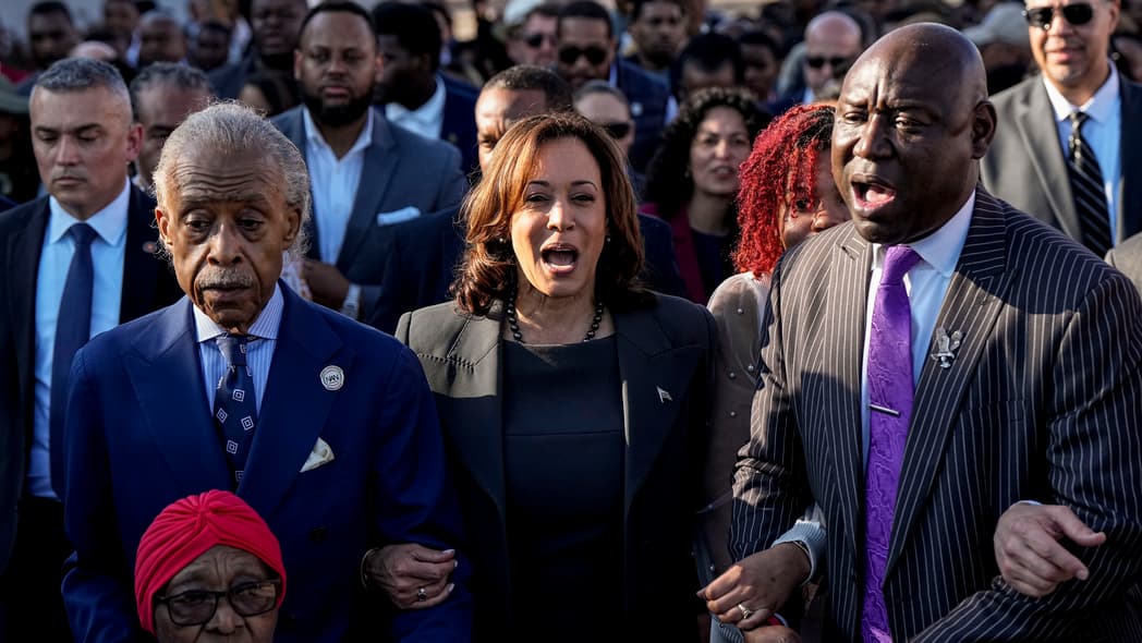 The Rev. Al Sharpton, Vice President Kamala Harris and Attorney Ben Crump walk and sing across the Edmund Pettus Bridge