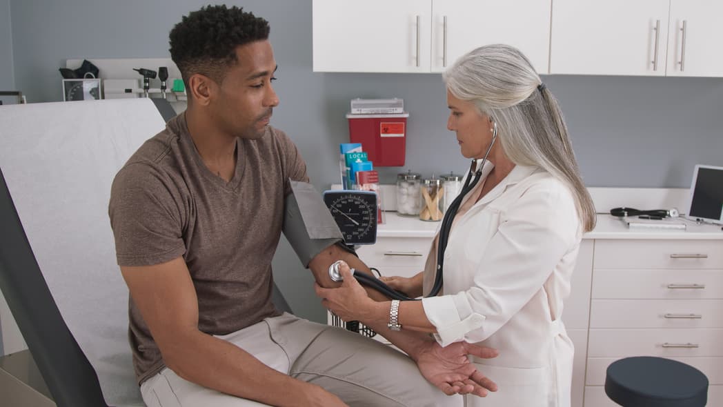 A doctor takes a man's blood pressure