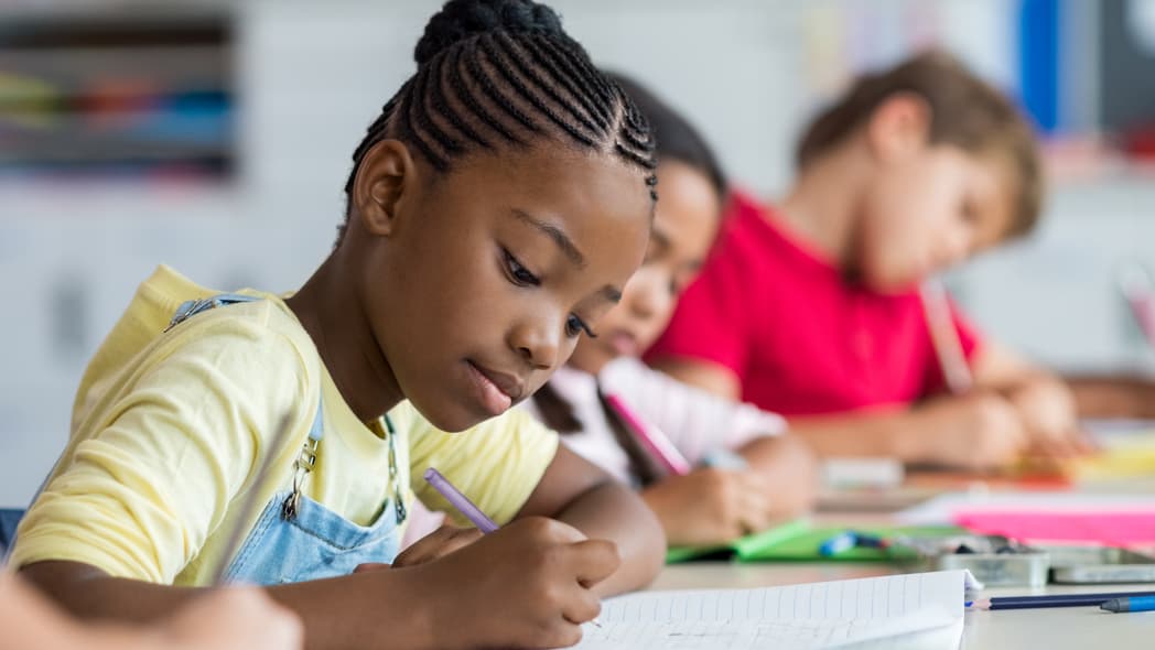 Children in a classroom writing on paper
