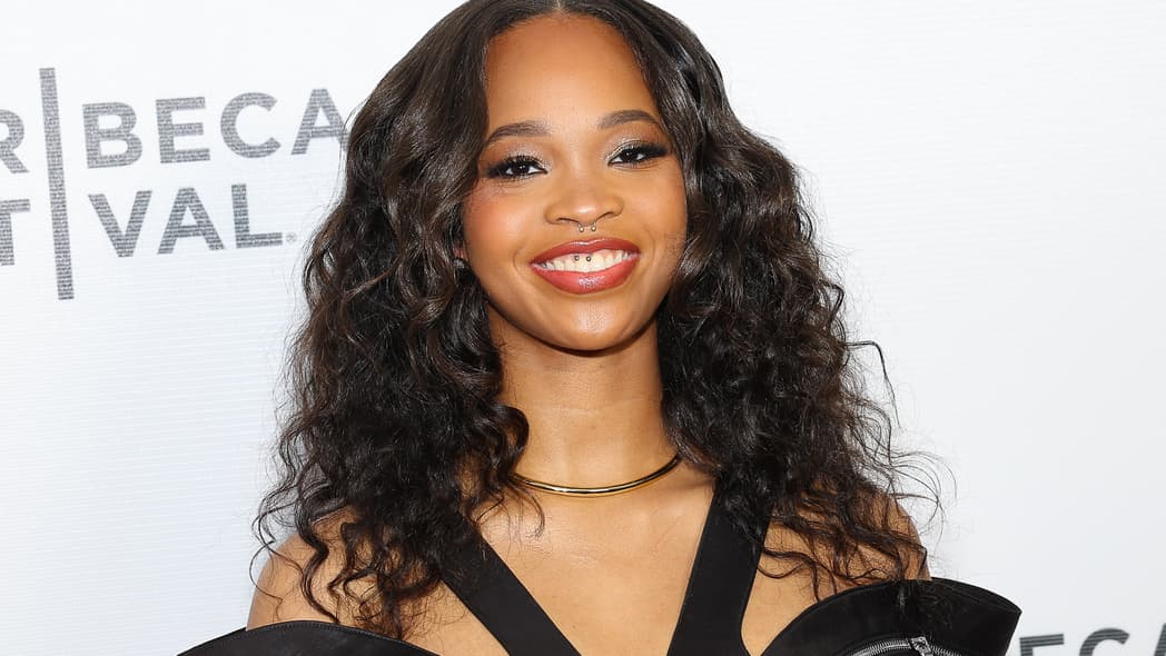 Actor Quvenzhané Wallis, wearing a black dress and gold necklace