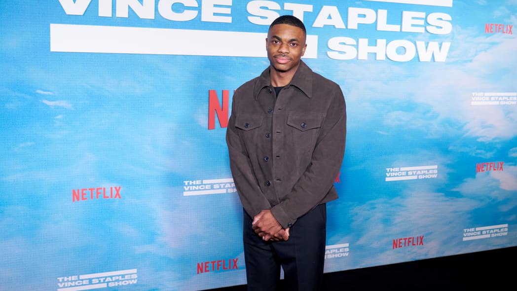 Rapper Vince Staples wearing a gray shirt and navy pants