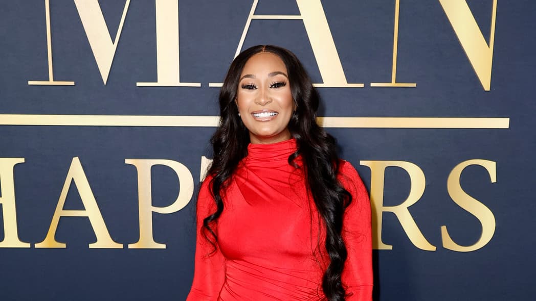 Melody Holt of OWN's "Love & Marriage: Huntsville" wears a long red dress and straight black hair to The Best Man event in Hollywood