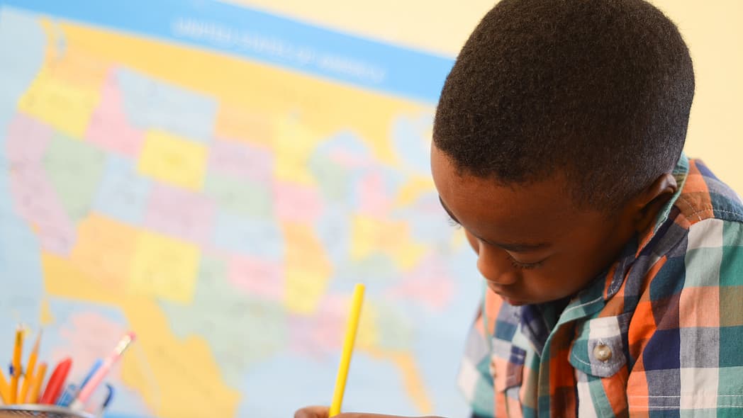 Black student doing school work in classroom, theGrio.com