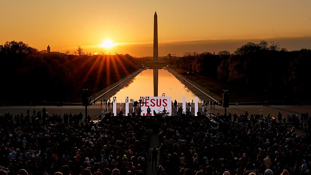 The word "Jesus" is displayed on a large monitor at an Easter sunrise service